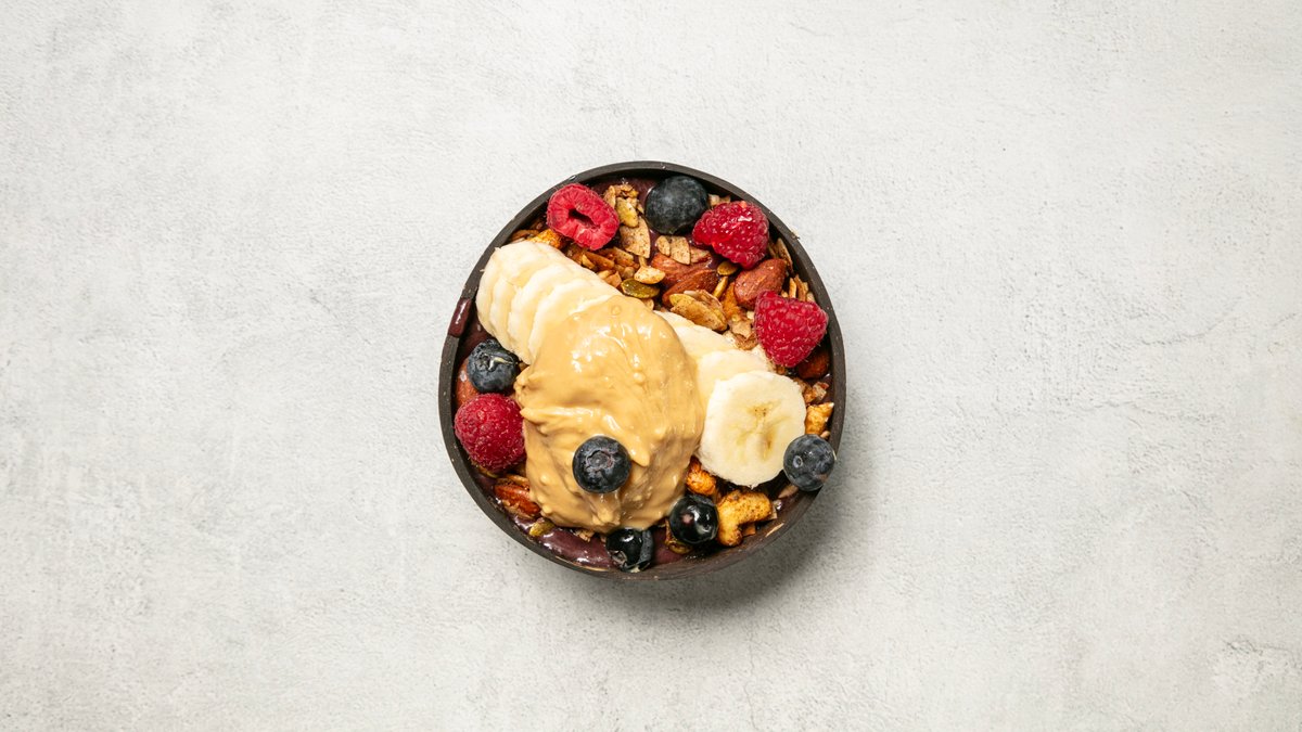 Berry Dream Acai Bowl + dryck – Färskfrusen Açaí mixad med banan och honung. Toppad med glut...